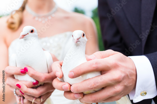 Brautpaar bei Hochzeit mit weißen Tauben photo