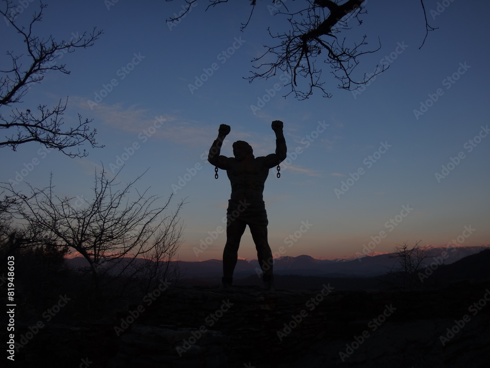 Силуэт человека на фоне синего закатного неба и горных вершин