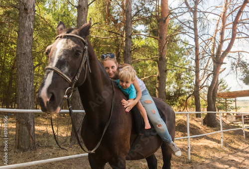 Mum with small son drive on horse