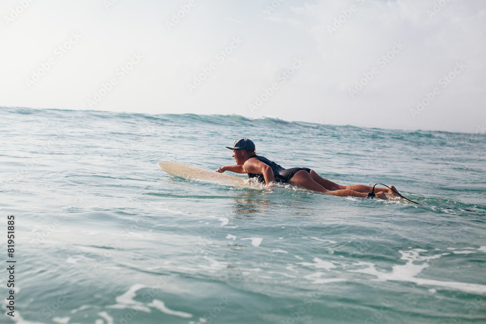 woman surfer swimming in sea