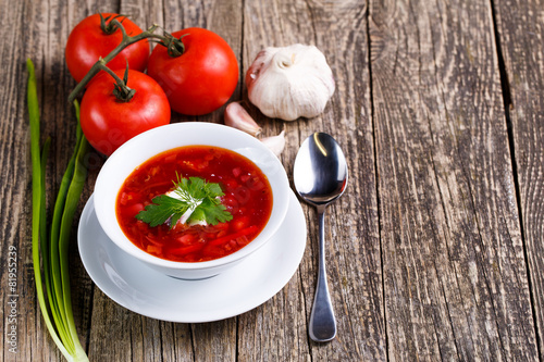 Borsch with bread on a wooden background.