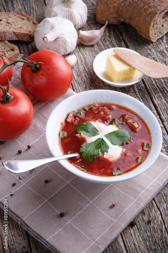 Borsch with bread on a wooden background.
