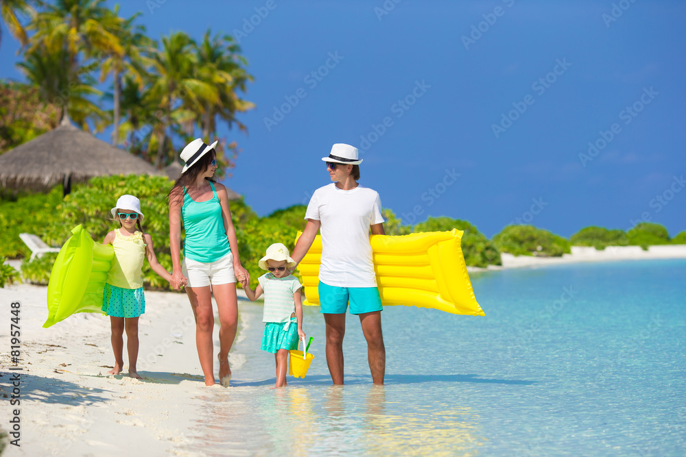 Happy beautiful family on white beach with inflatable air