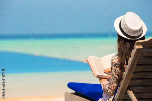 Young woman read book near swimming pool