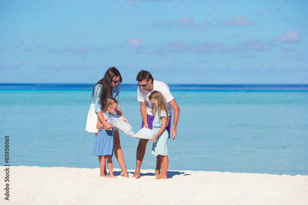 Happy family with map on the beach Happy family with map on the beach