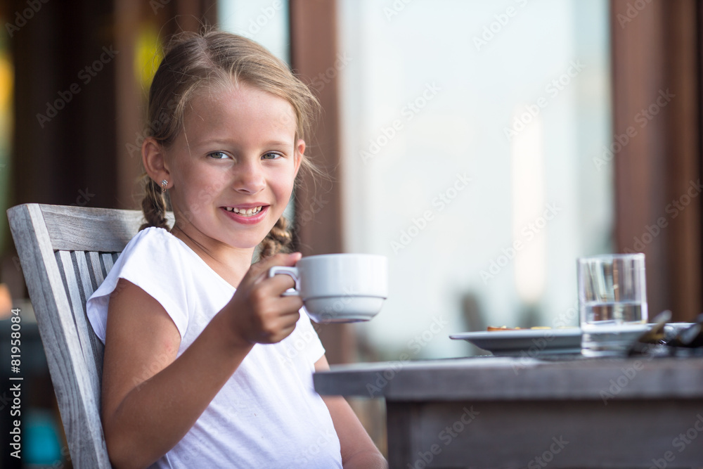 Little adorable girl drinking tea on breakfast in outdoor cafe Little adorable girl drinking tea on breakfast in outdoor cafe