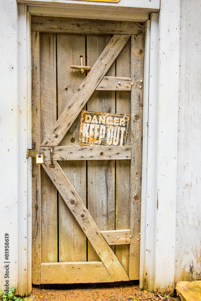 old wooden door with danger sign