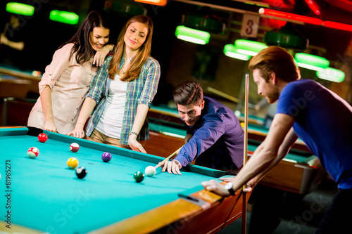 Young people playing pool © BGStock72