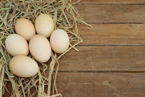 Egg in hay nest on wooden table background