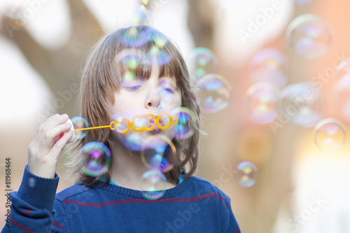 Boy with Blond Hair Blowing Bubbles