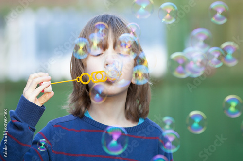 Boy with Blond Hair Blowing Bubbles