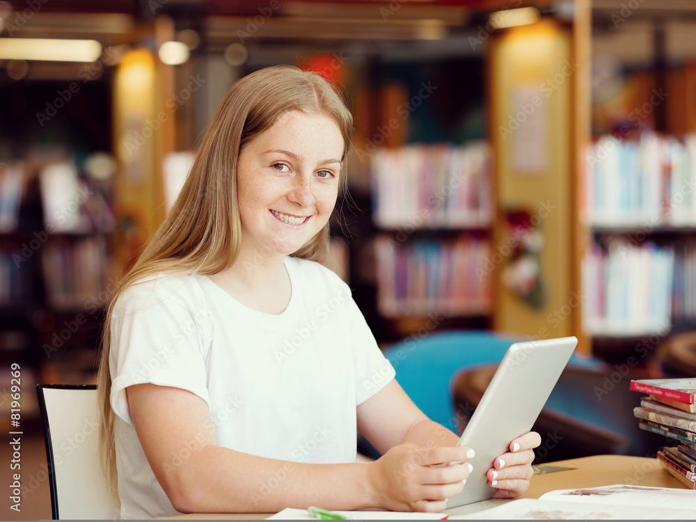Teenage girl with tablet in library Teenage girl with tablet in library