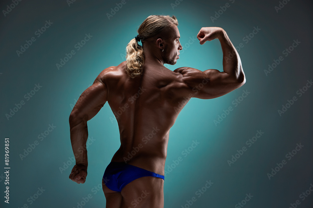 Obraz premium Attractive male body builder on blue background
