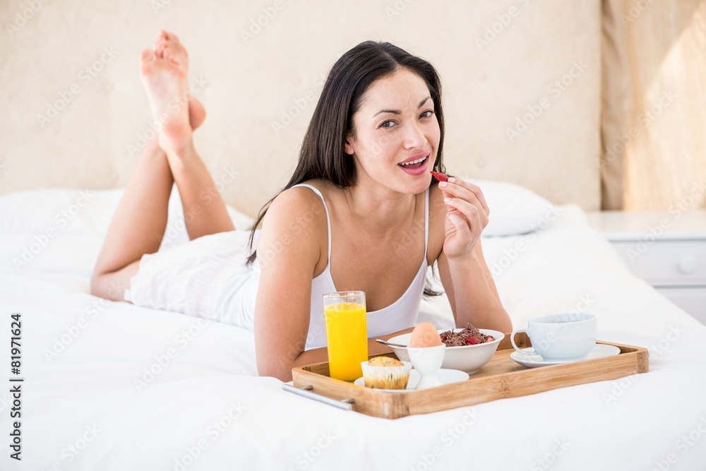 Pretty brunette eating her breakfast on bed Pretty brunette eating her breakfast on bed