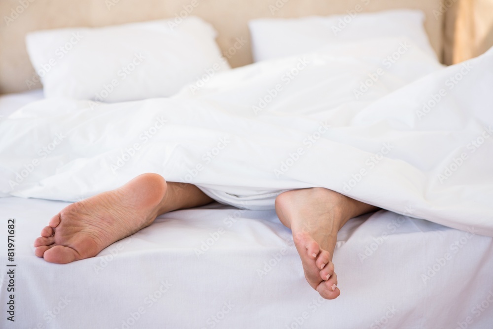 Woman feet under a duvet Woman feet under a duvet