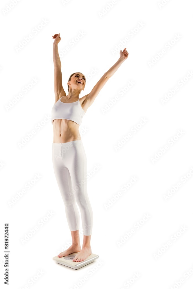 Slim woman cheering on scales Slim woman cheering on scales