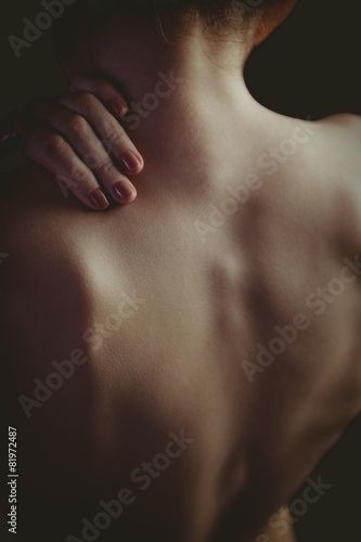 Nude woman with a shoulder injury
