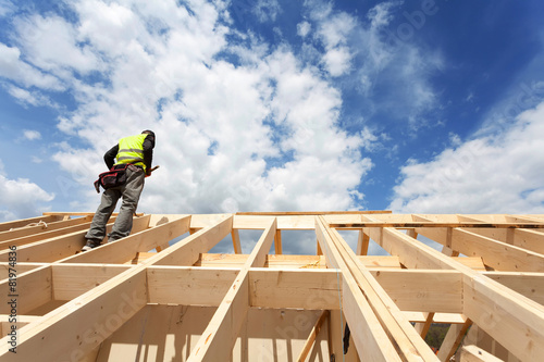 Construction crew working on the roof against blue sky