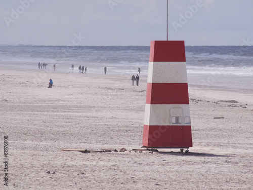 Red-and-white tower at the beach photo