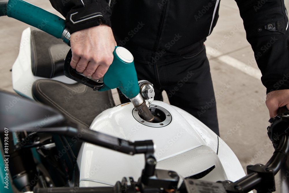 hand fuel nozzle in pouring to motorcycle at gas station hand fuel nozzle in pouring to motorcycle at gas station