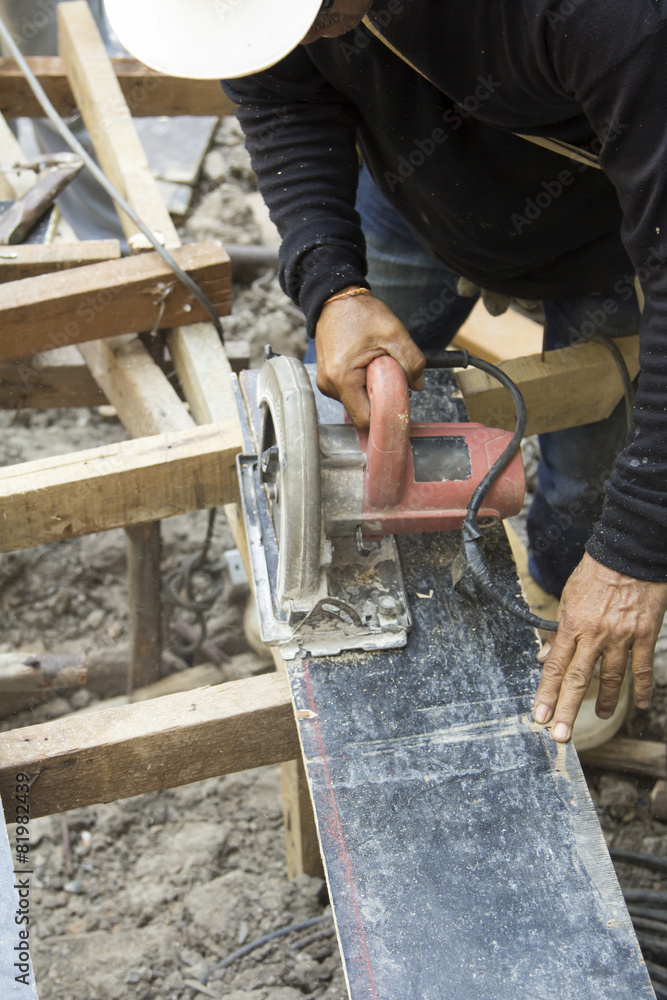 Worker with circular saw machine cutting wood. Worker with circular saw machine cutting wood.