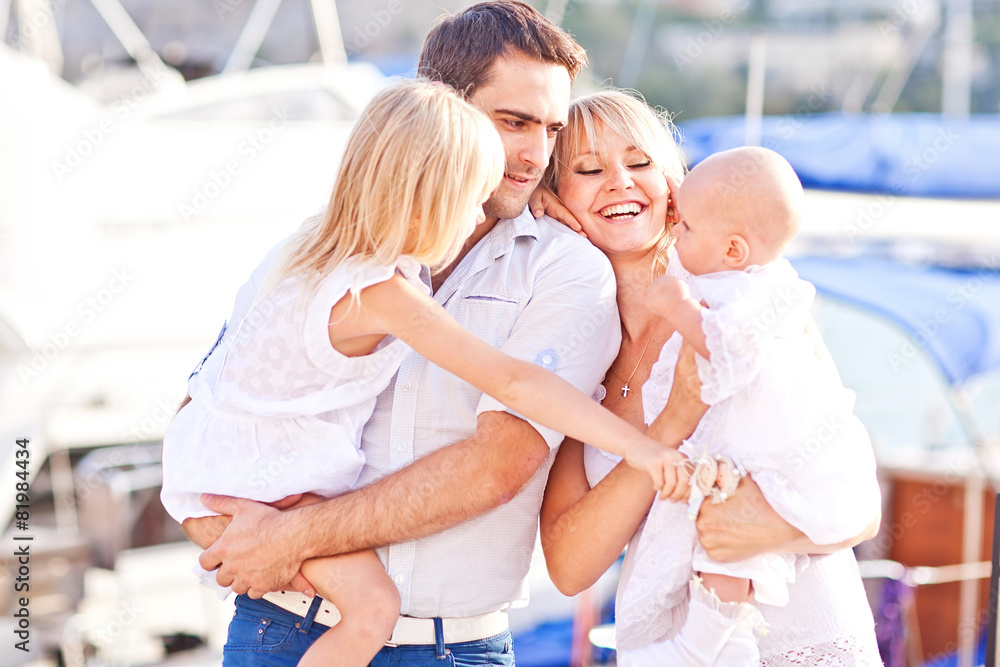 Obraz premium Happy family having fun walking on the mooring near yachts