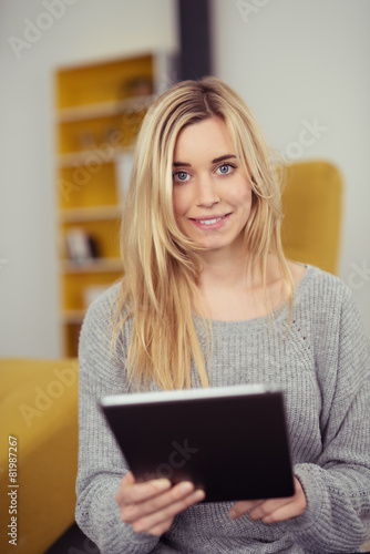 moderne junge frau liest zuhause am tablet-pc