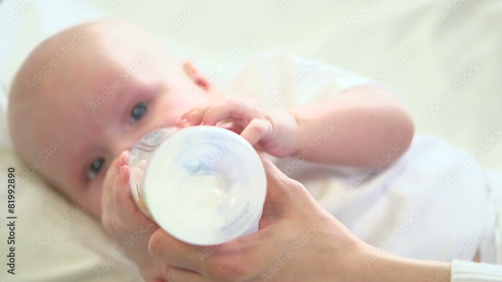 Newborn Baby eating milk from the bottle. Slow motion Newborn Baby eating milk from the bottle. Slow motion
