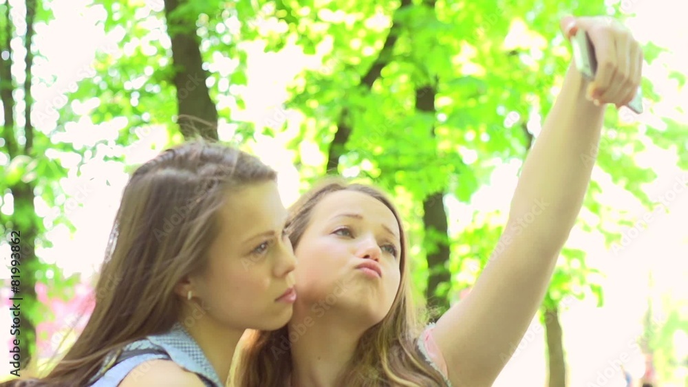 Outdoor portrait of teen girls making selfie. Slow motion Outdoor portrait of teen girls making selfie. Slow motion