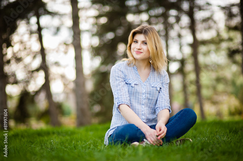 Tableau sur toile portrait of a beautiful woman sitting in grass