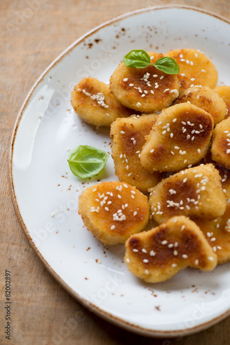 Close-up of chicken nuggets with sesame seeds and basil
