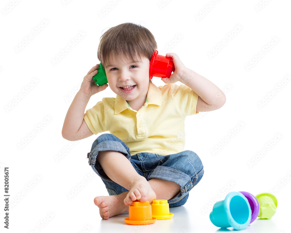 little kid is playing with toys while sitting on floor, isolated little kid is playing with toys while sitting on floor, isolated