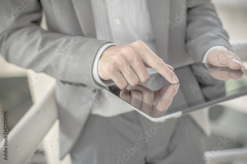 Businessman using electronic tablet pc. He is sitting on a stair