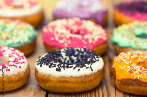 Colorful glazed donuts on the wooden table