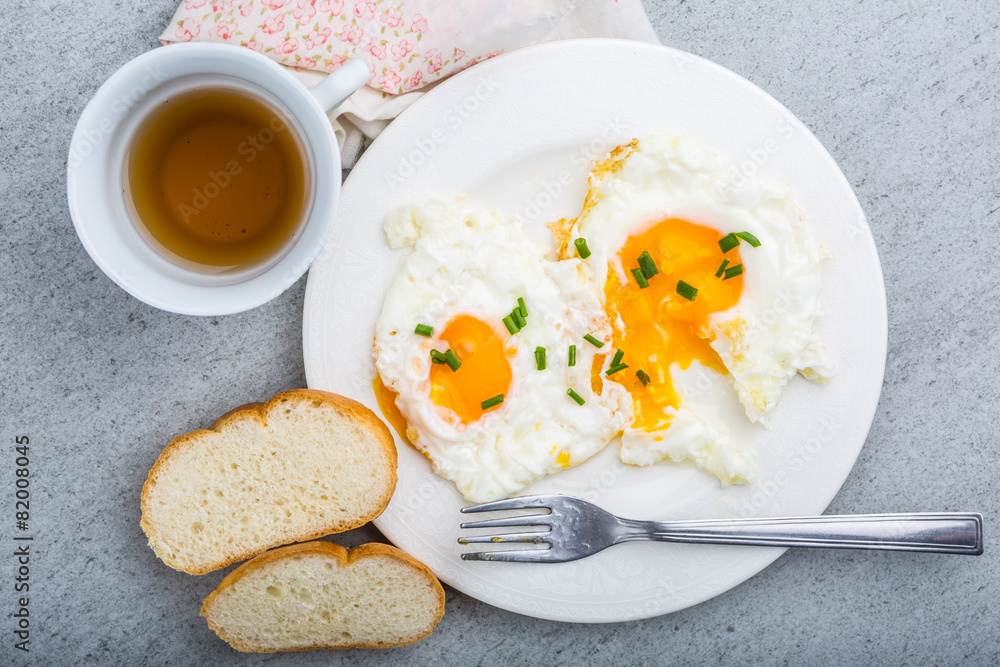 Two fried eggs with chives on white plate Two fried eggs with chives on white plate