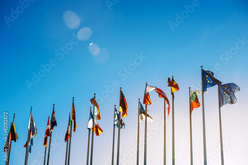 All European Union flags against blue sky in front of parliament