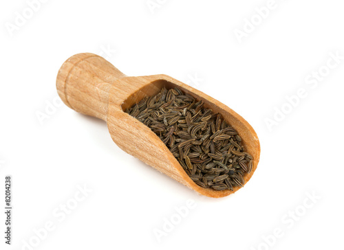dried cumin in a wooden spoon