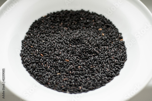 Black rice heap in ceramic dish top view isolated
