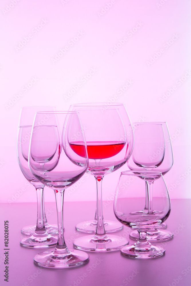 glass with wine on pink background