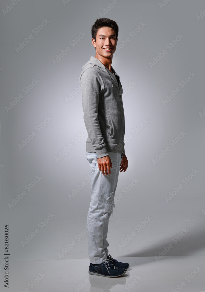 Full body Side view a young man, isolated-gray background Full body Side view a young man, isolated-gray background