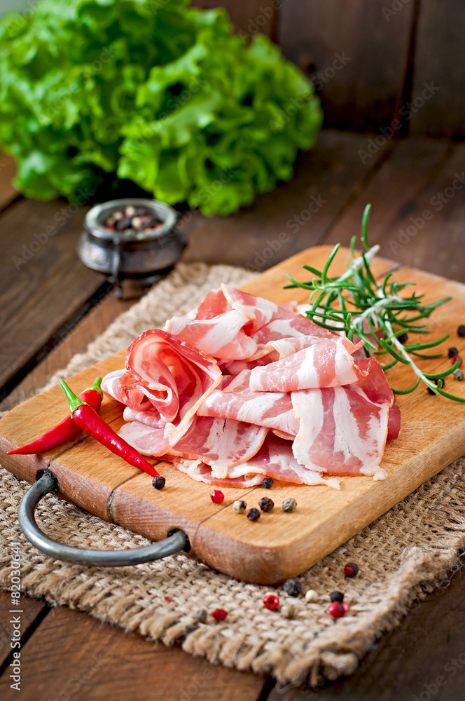 Slices of bacon on the wooden background Slices of bacon on the wooden background