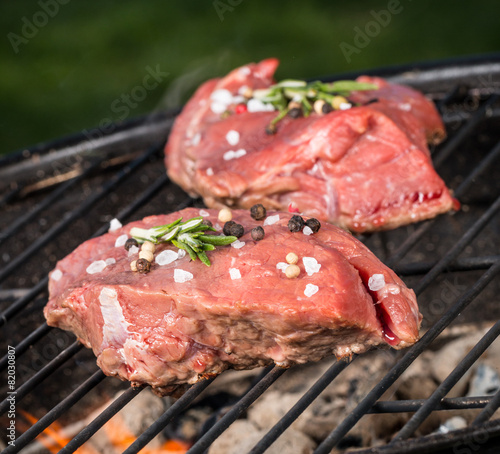 Raw beef steaks on grill