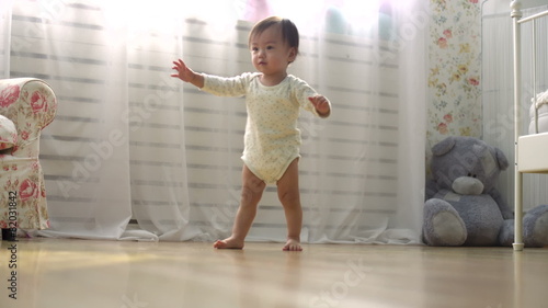 one year a small asian baby taking its first steps,dolly shot