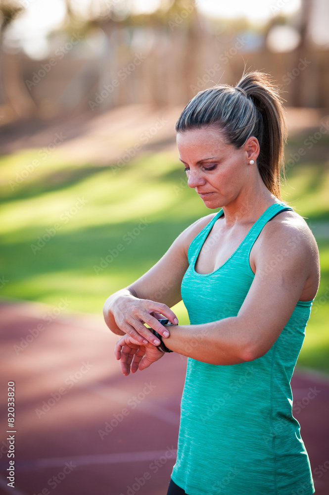 image of a female athlete adjusting her heart rate monitor image of a female athlete adjusting her heart rate monitor