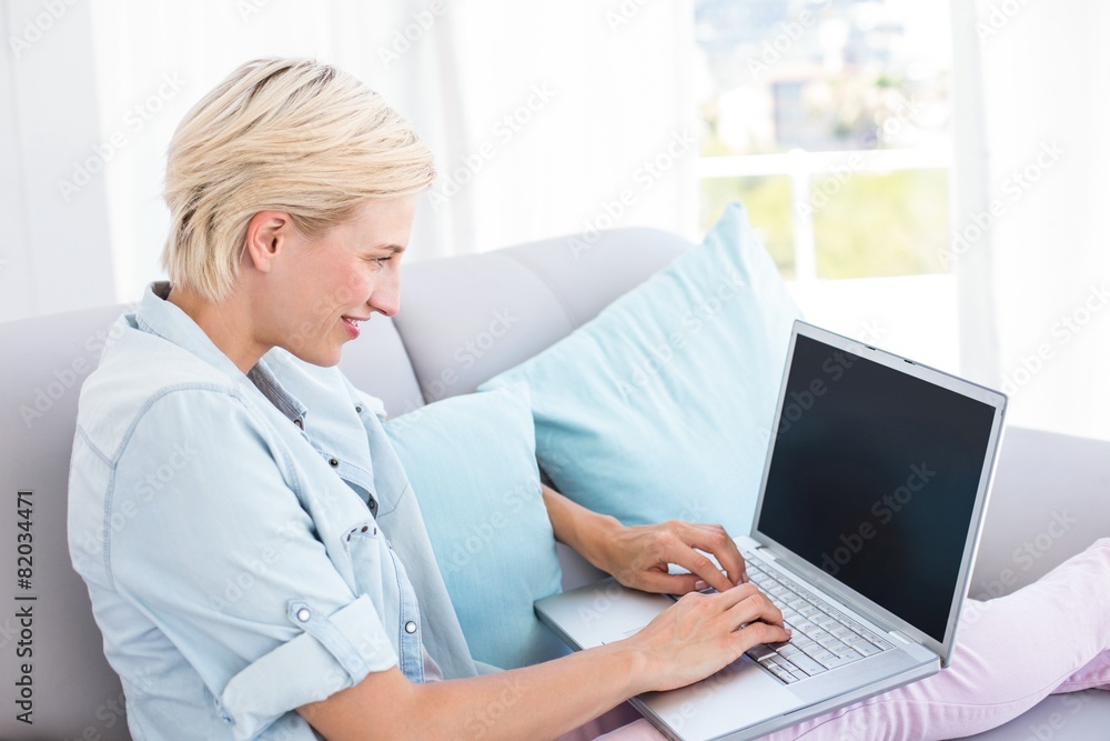Pretty blonde woman using her laptop on the couch Pretty blonde woman using her laptop on the couch