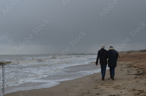 couple walking along coastline, Belgian shore