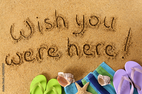 Canvas-taulu Wish you were here classic postcard or post card message written in sand on a tr