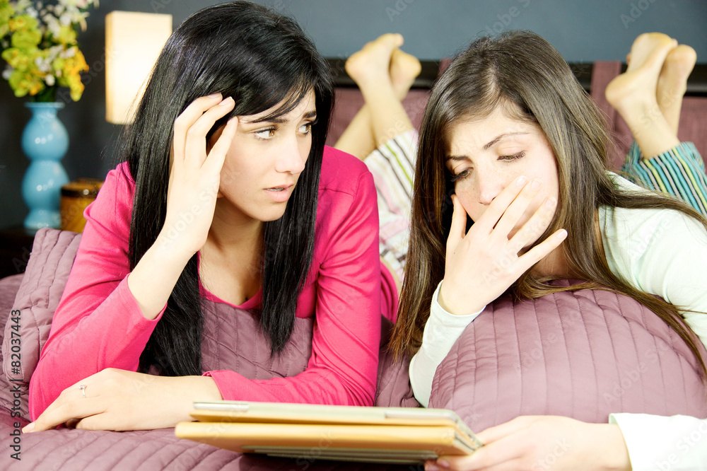 Girlfriends sad in bed reading tablet Girlfriends sad in bed reading tablet