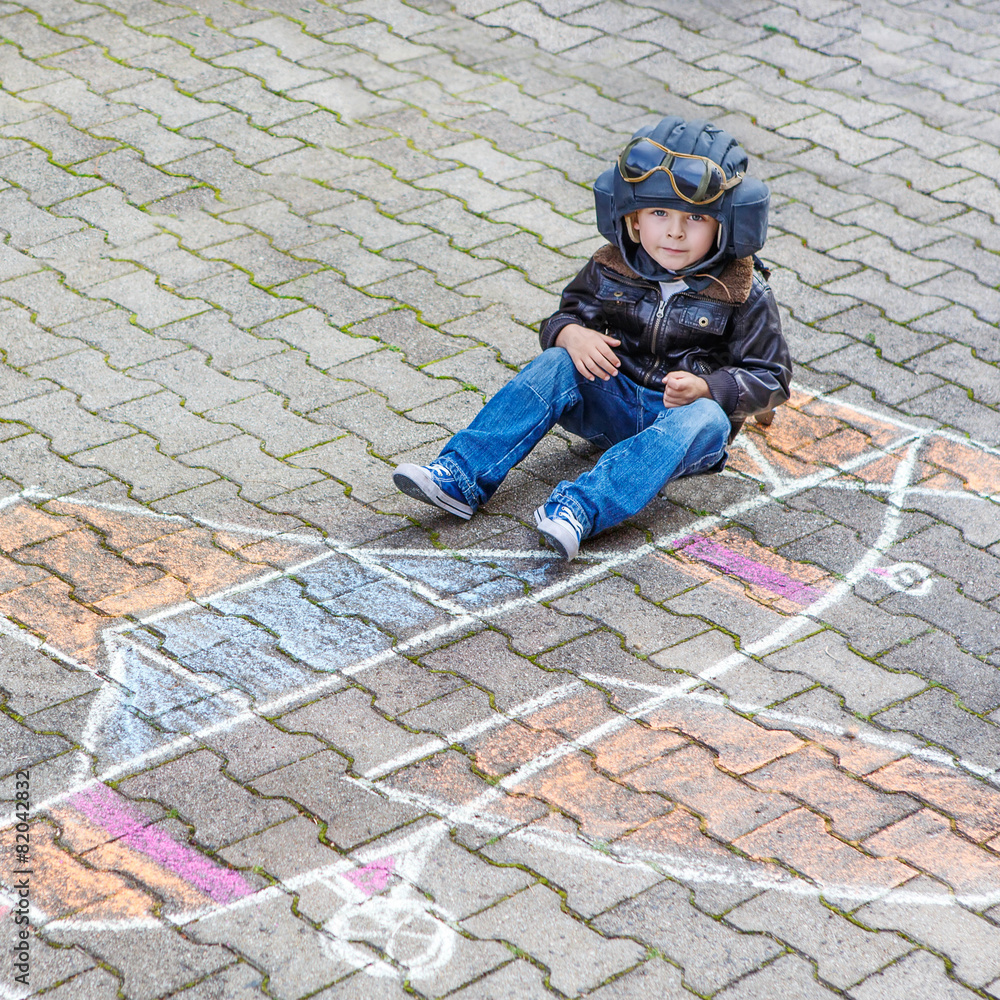 Little boy having fun with airplane picture drawing with chalk Little boy having fun with airplane picture drawing with chalk