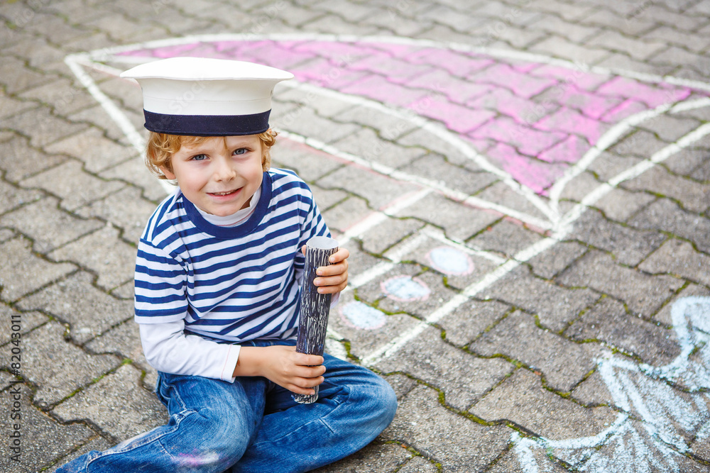 Little kid boy having fun with ship picture drawing with chalk Little kid boy having fun with ship picture drawing with chalk